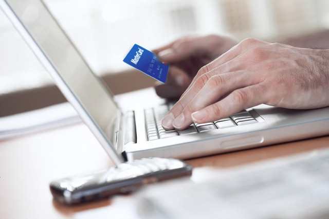 Man shopping online with credit card --- Image by © Kate Kunz/Corbis